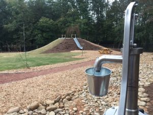 A hand water pump provides hands-on engagement and sensory exploration.